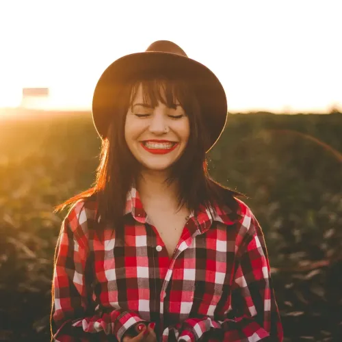 woman smiling with sunbeams behind her